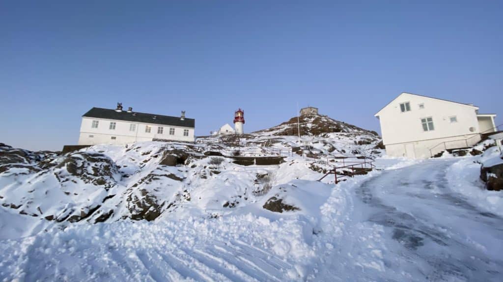 Snø med blikk opp på fyrtårnet. Lindesnes fyrmuseum. Foto: Thea Jåvold